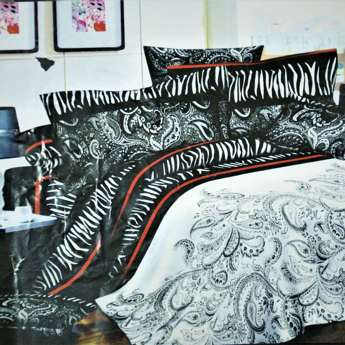 Black and white zebra-stripe and paisley print bedsheet set with a red piping border, styled on a bed with matching pillow covers