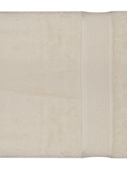 Cream cotton bath towel with a textured dobby band border, folded, 30x60 inch