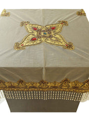 Beige net table cover with a star-shaped gold-beaded medallion embroidered at the centre, accented with red and turquoise stones, edged with a beaded fringe border