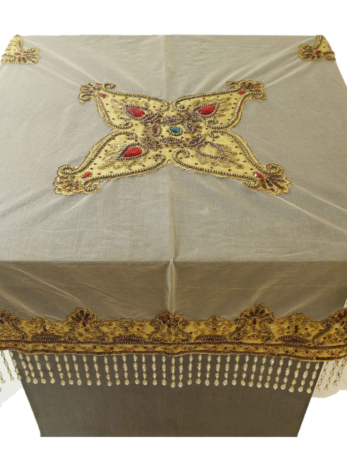 Beige net table cover with a star-shaped gold-beaded medallion embroidered at the centre, accented with red and turquoise stones, edged with a beaded fringe border