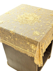 Beige net table cover with a gold sequinned and embroidered floral medallion at the centre and a scalloped lace border