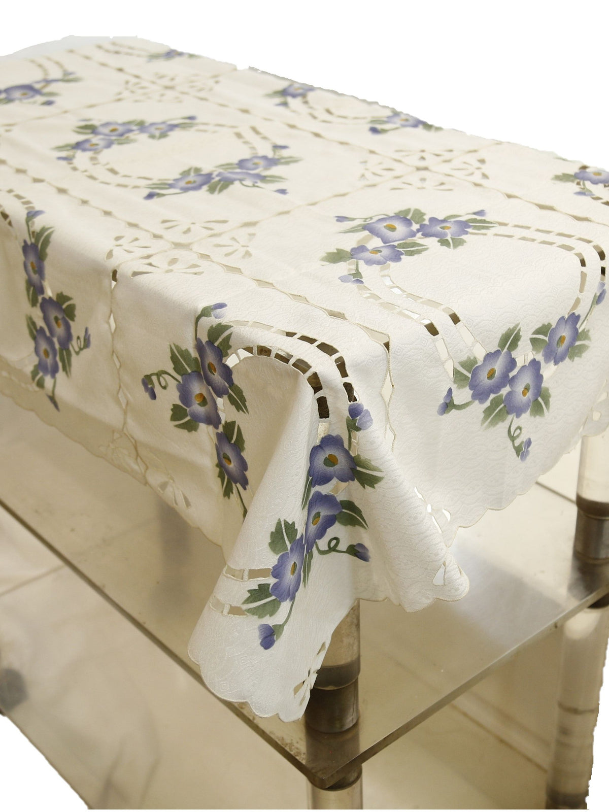Cream table cover with a cutwork lattice pattern, printed purple-blue floral bouquets, and a scalloped cutwork hem