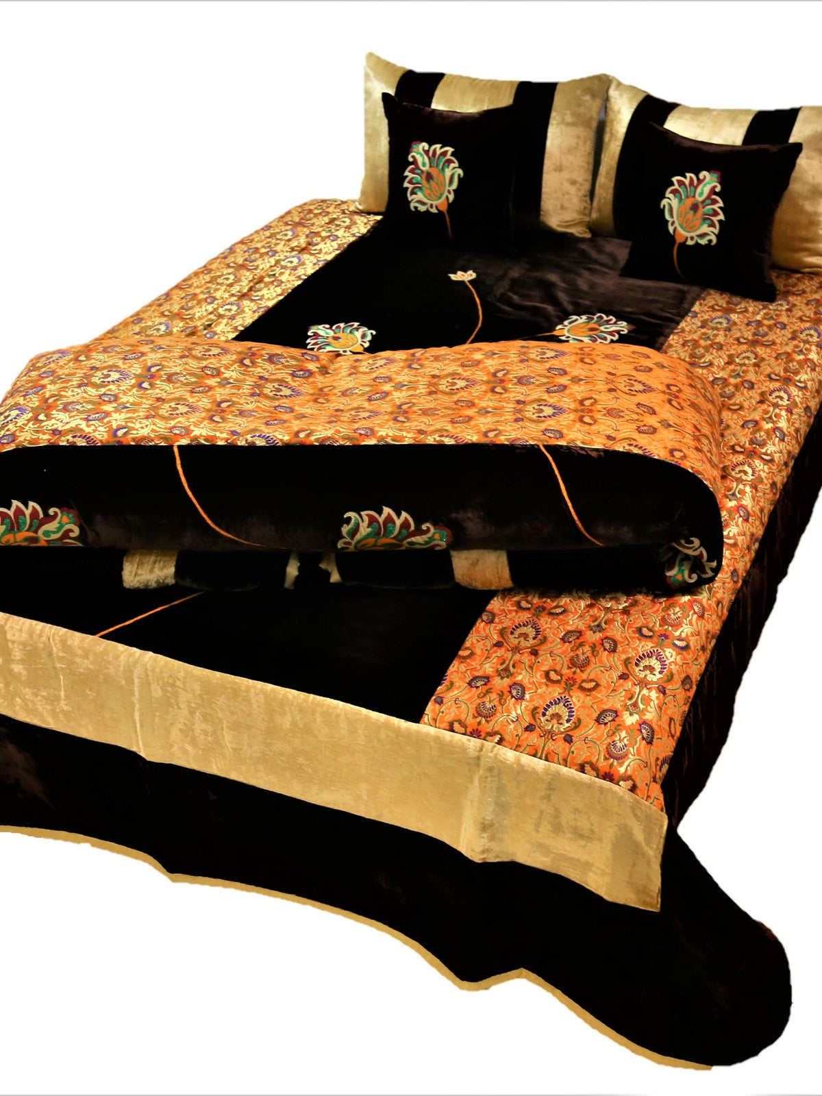Black and gold flower embroidered velvet wedding set on a double bed, angled view