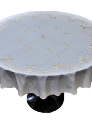 Round ivory table cover with a cream embroidered bow-and-garland pattern and a scalloped edge