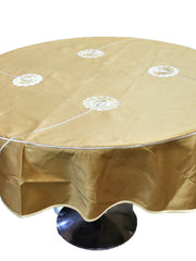 Round solid gold table cover with scattered white flower appliqués and a scalloped hem