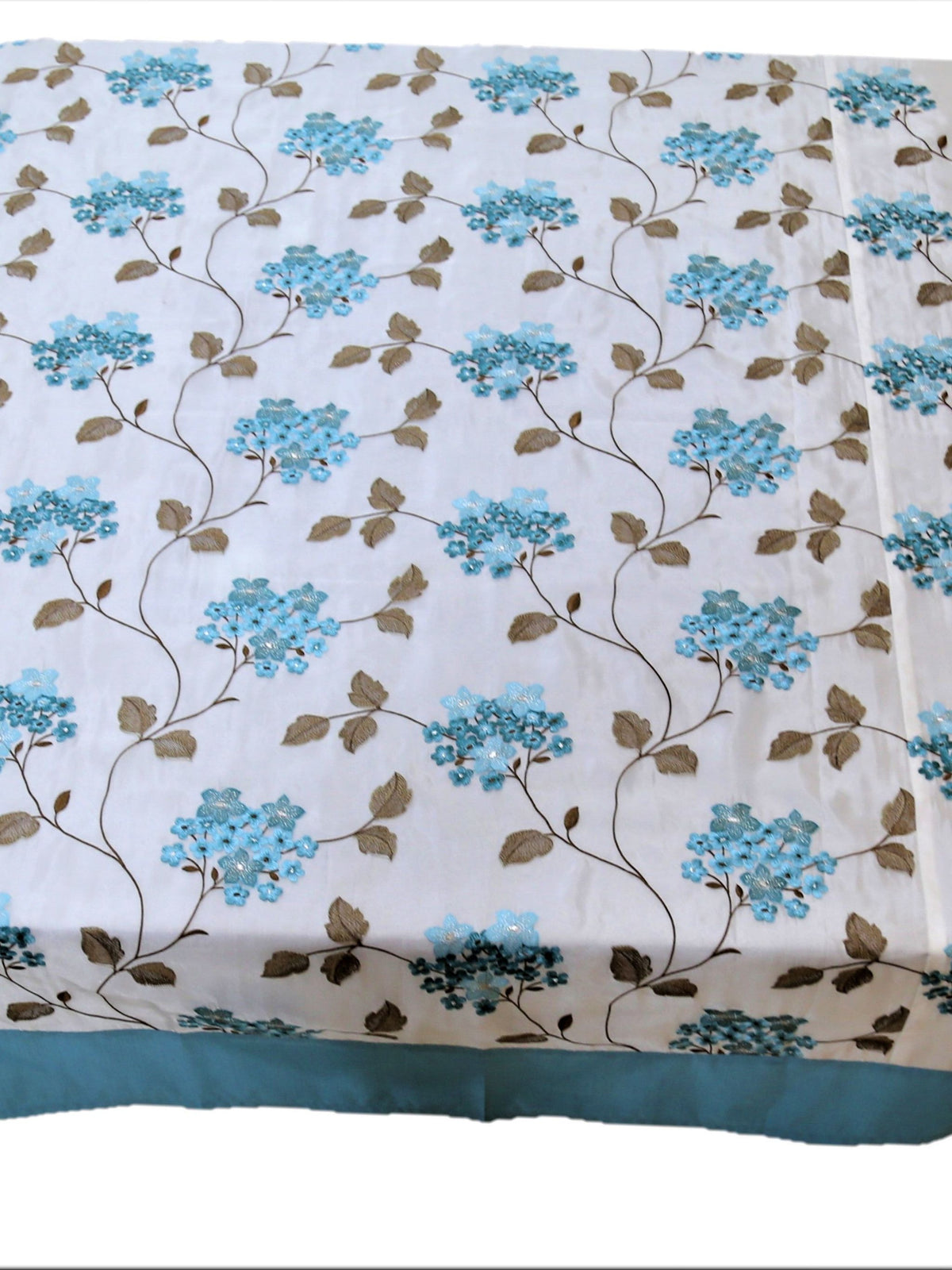 White table cover with a blue embroidered hydrangea floral pattern, brown leaves, and a teal-blue border