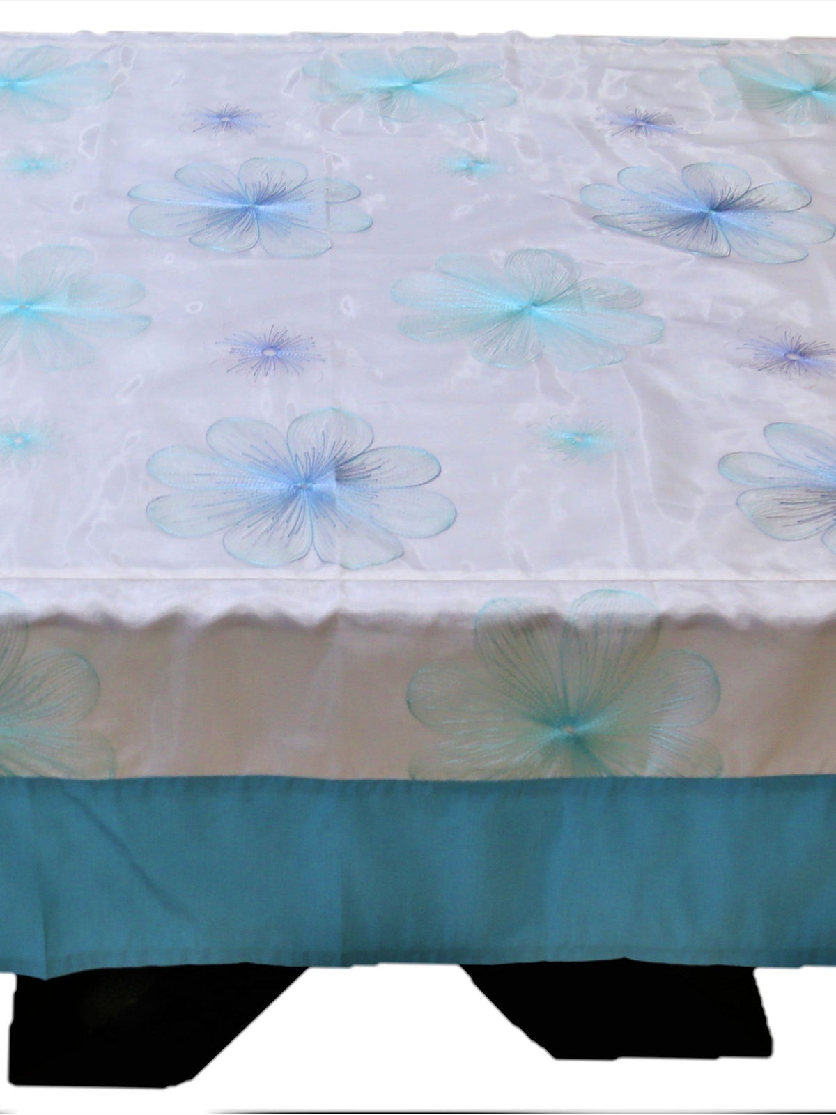 White table cover with a pale blue embroidered flower pattern and a solid teal-blue underskirt