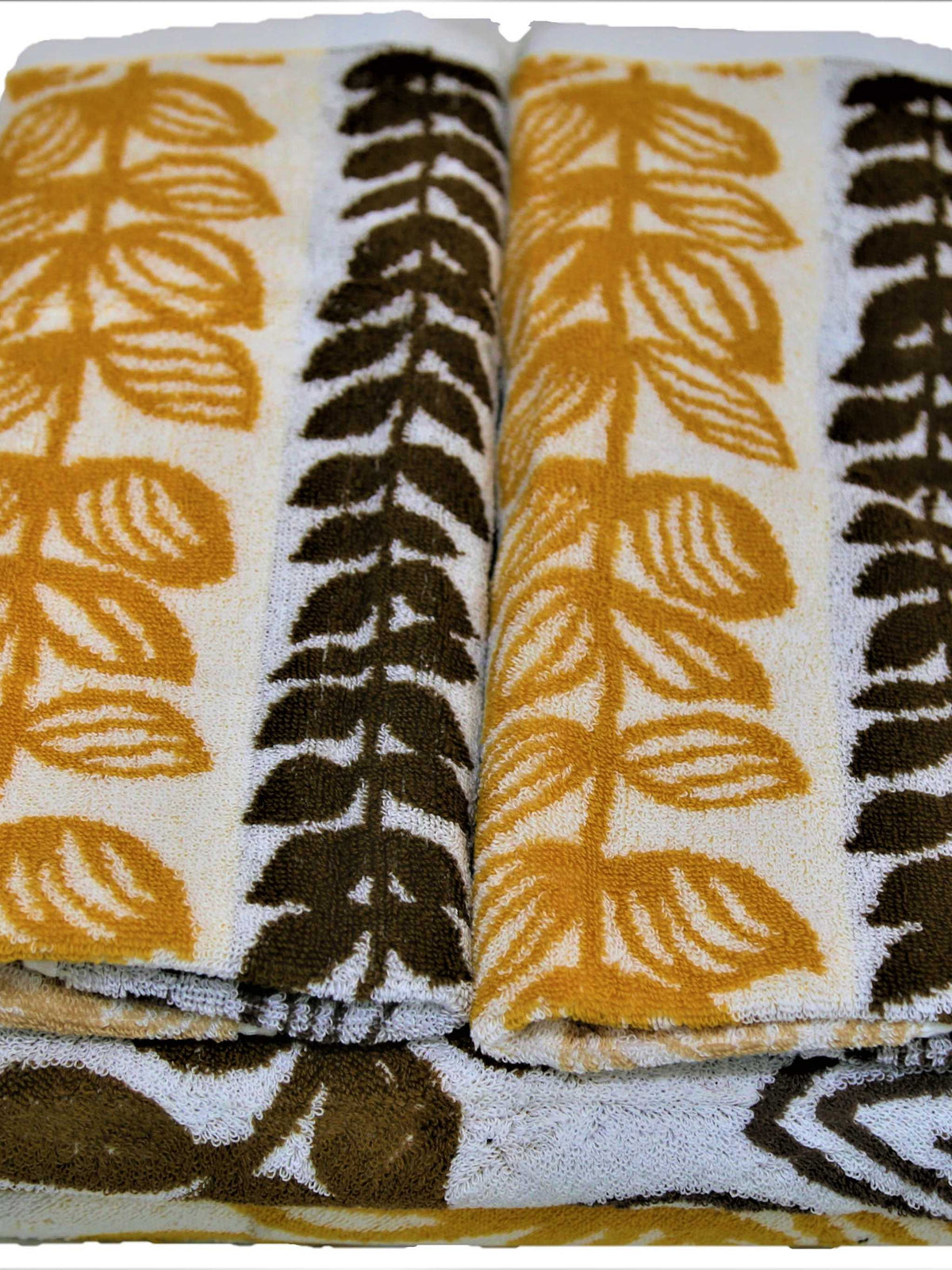 White cotton towel set with a gold and brown leaf-print stripe pattern