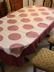 White oval table cover with a maroon circular medallion print and a solid maroon border
