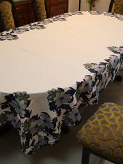 White oval table cover with a printed navy, purple, and green floral border pattern