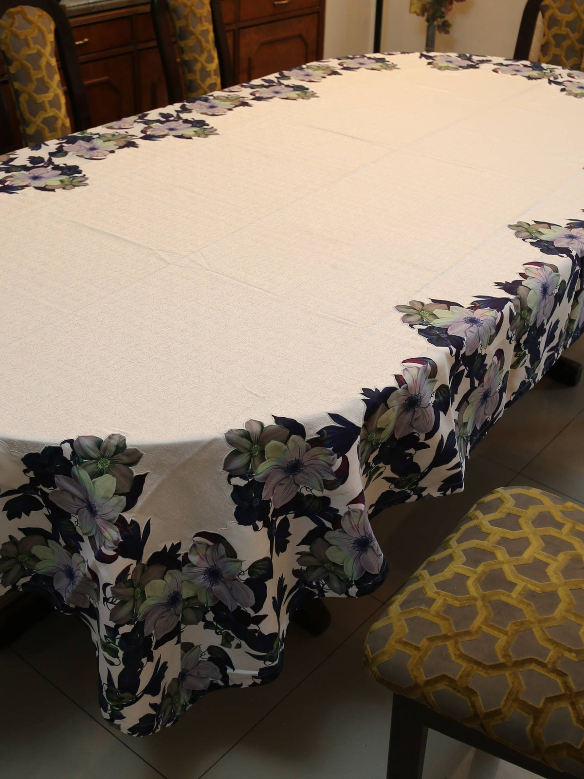 White oval table cover with a printed navy, purple, and green floral border pattern