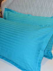 Turquoise cotton satin pillow covers with a self stripe, shown on a bed, 18x27 inch