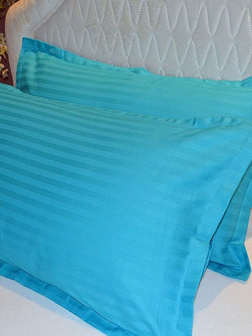 Turquoise cotton satin pillow covers with a self stripe, shown on a bed, 18x27 inch