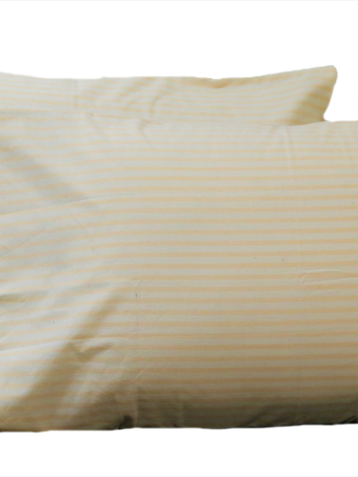 Cream cotton pillow covers with a fine self stripe, shown on a bed