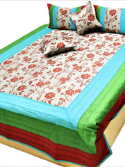 Green, red and blue bordered quilted bedcover set with a floral centre panel on a bed