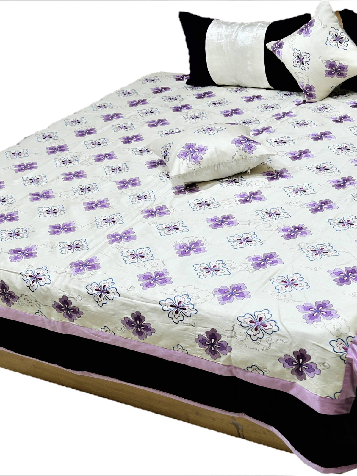 White quilted bedcover set with small purple flower motifs and black bordered pillow covers