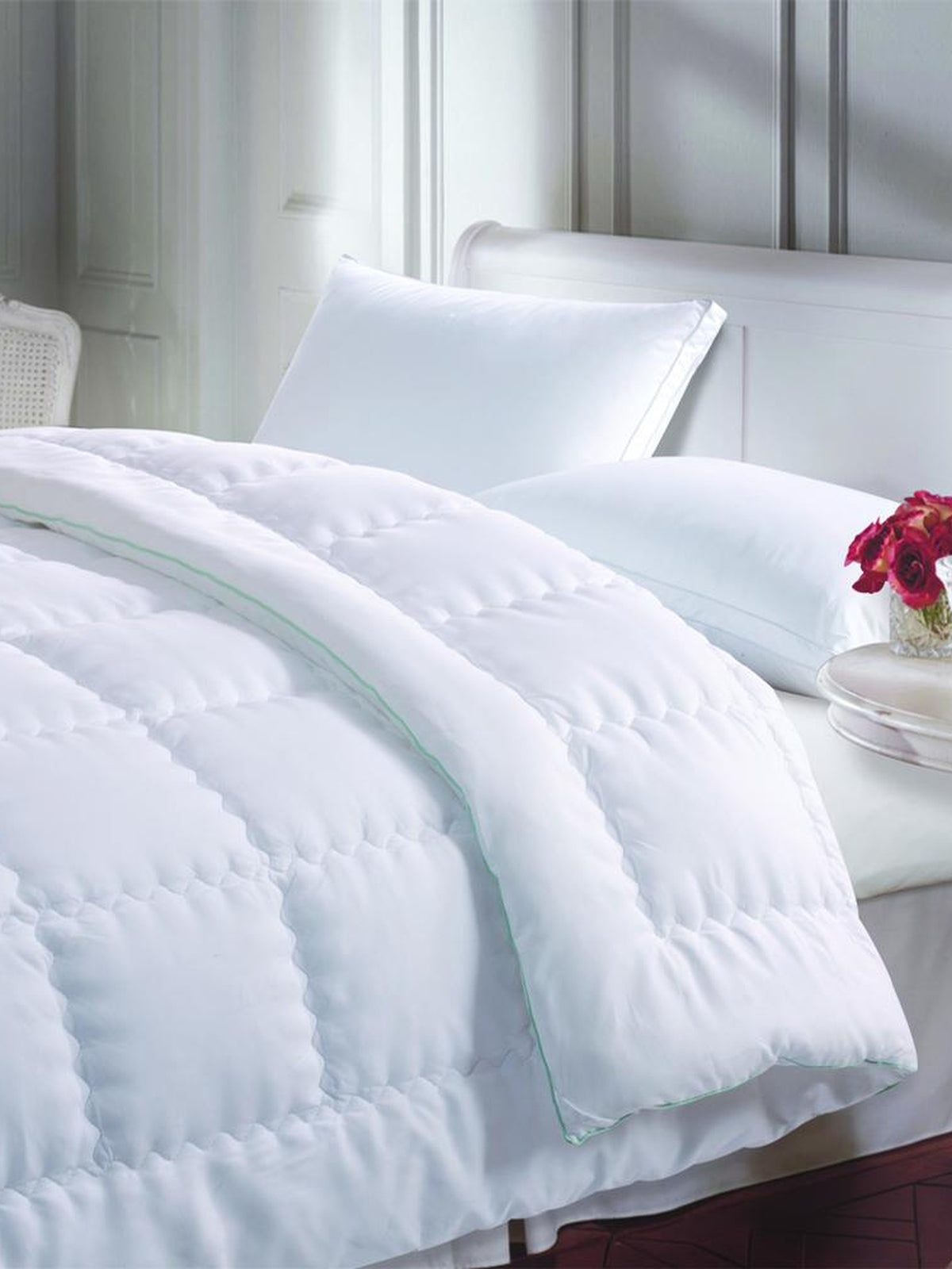 Crisp white microfiber king bed quilt with mint-green piped edge