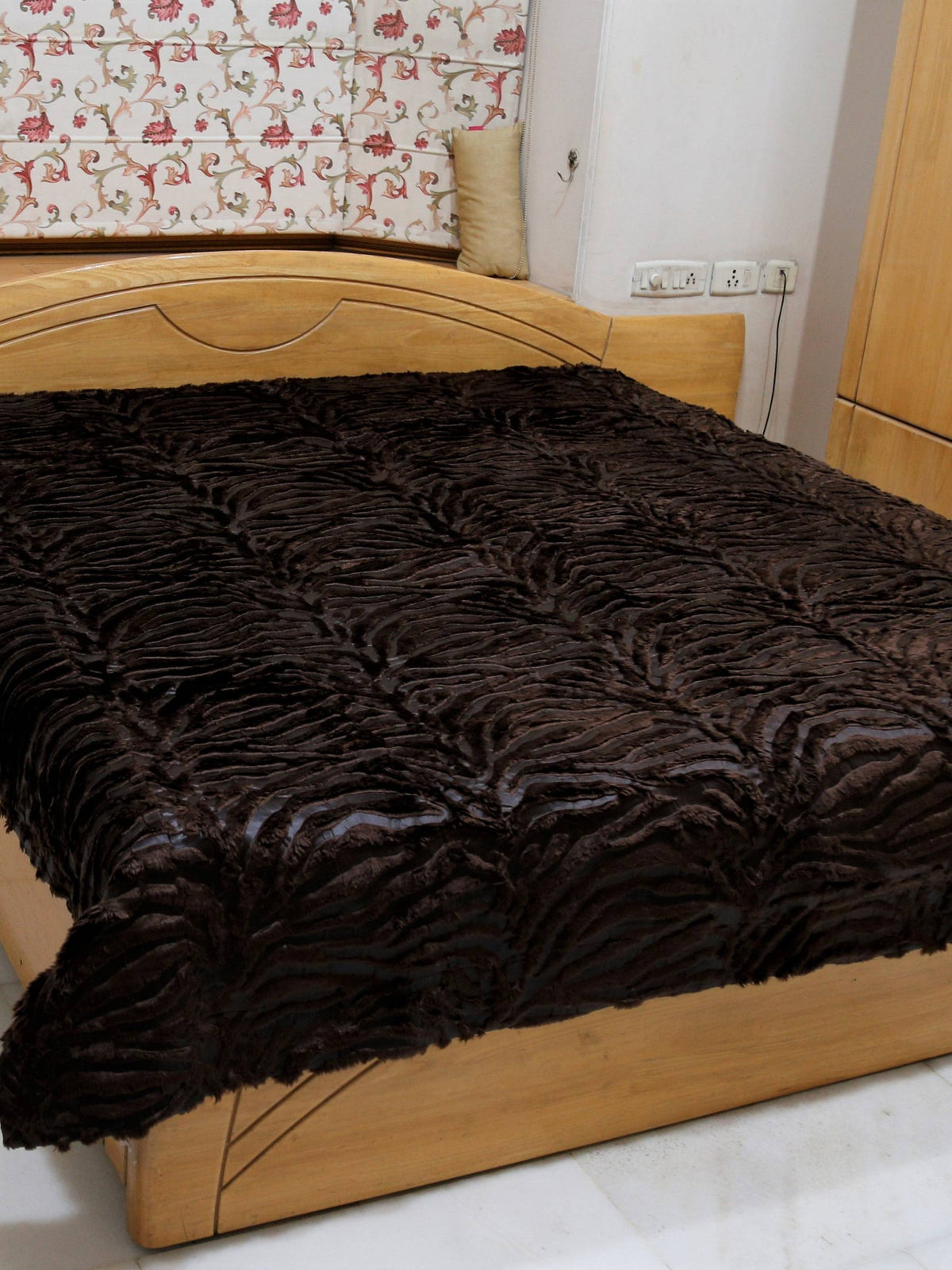 Mora chocolate-brown faux-fur blanket spread over a double bed