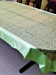 Olive-green table cover with a white and silver embroidered leaf-and-vine pattern and a pale mint-green satin border