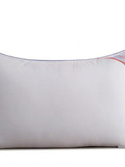 Close-up of the white Homescapes Cloud pillow with its blue and red piped edge