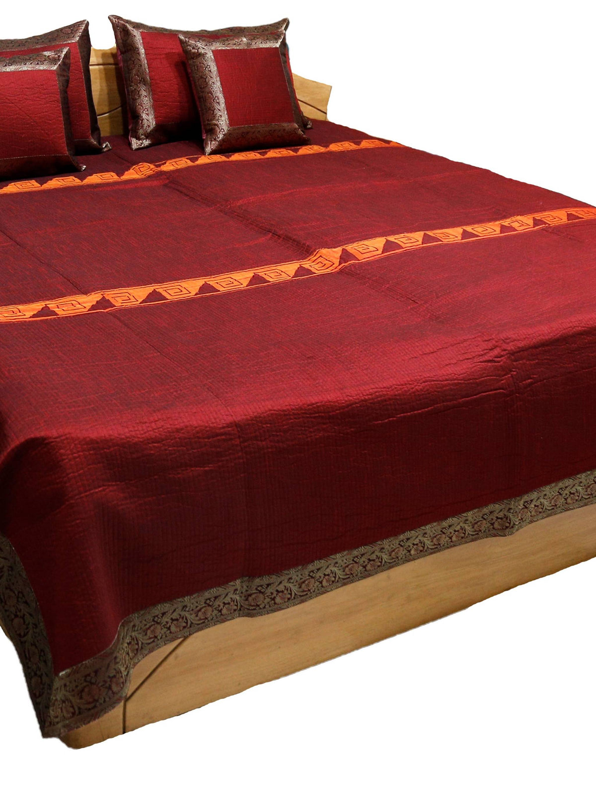 Maroon-red satin double bedcover with a grey-brown zari-brocade border, styled with matching pillow and cushion covers