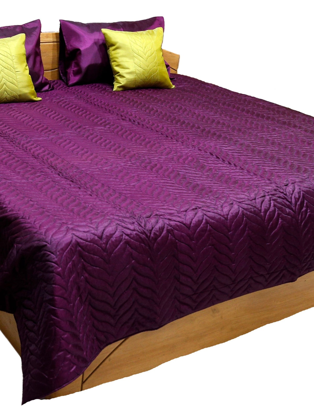 Deep purple embossed quilted double bedcover with matching purple pillow covers and chartreuse-yellow embossed cushion covers