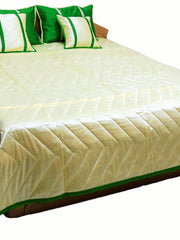 Cream reverse side of the bedcover with green bordered edge and green cushions