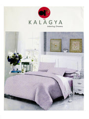 Kalagya Weaving Dreams packaging showing a lavender-white bedsheet set with a small pink and purple diamond-lattice print, styled on a bed with a floral nightstand display