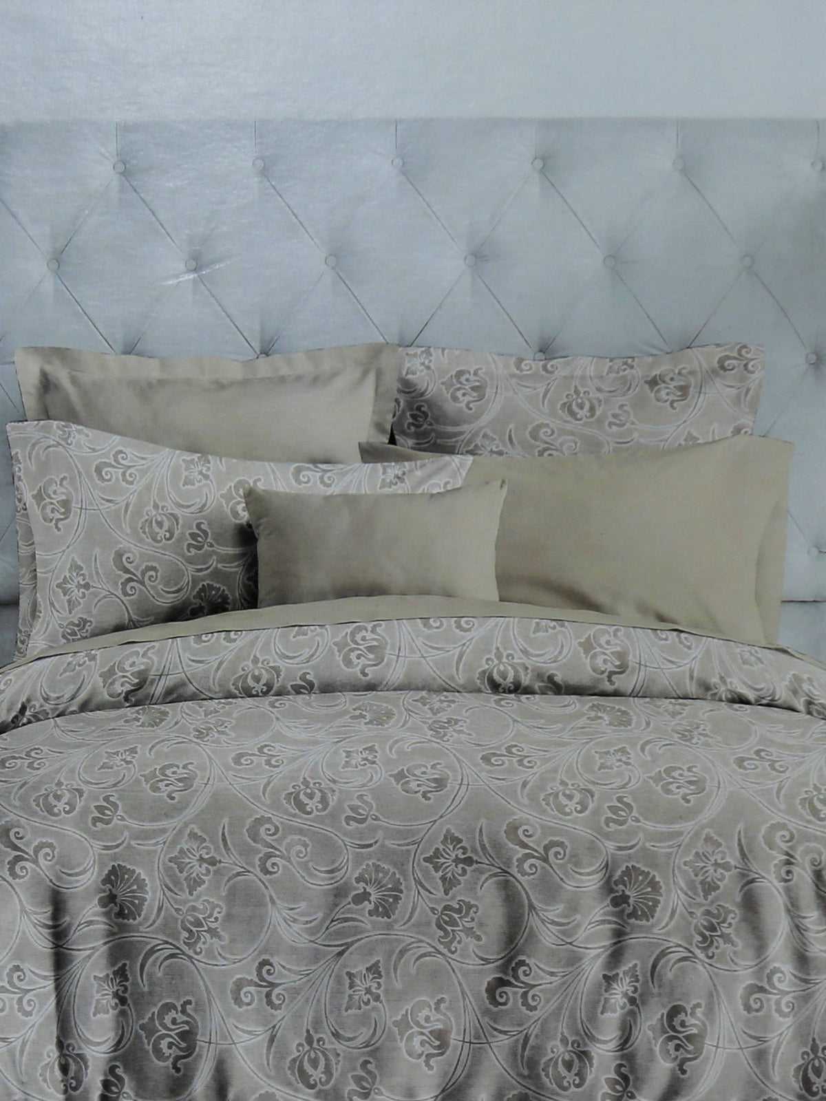 Grey paisley print cotton bedding made up on a tufted bed, Trident Nectarsoft