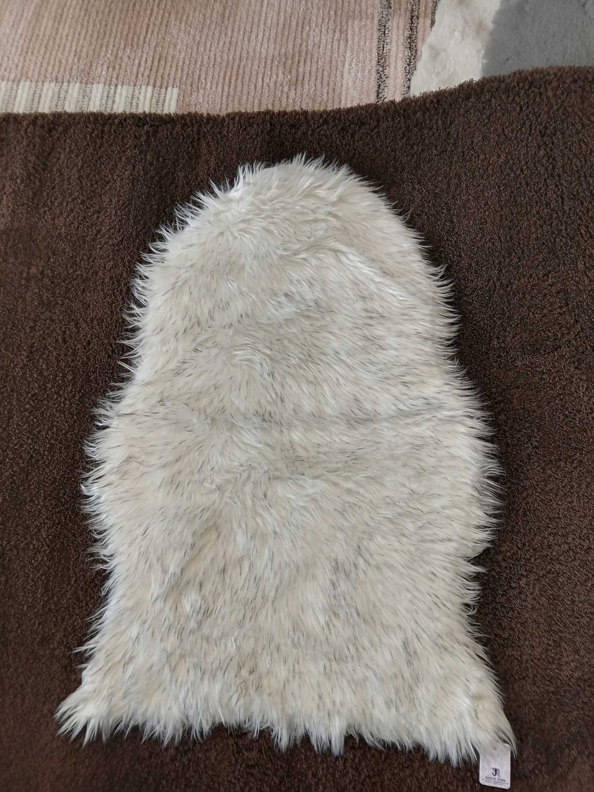 Cream faux sheepskin bedside runner with a long shaggy pile