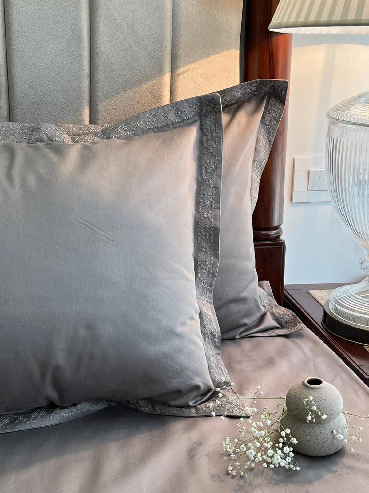 Elephant grey sateen bedding with a textured band pillow border, styled on a bed