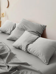 Silver grey sateen bedding and pillows on a made bed