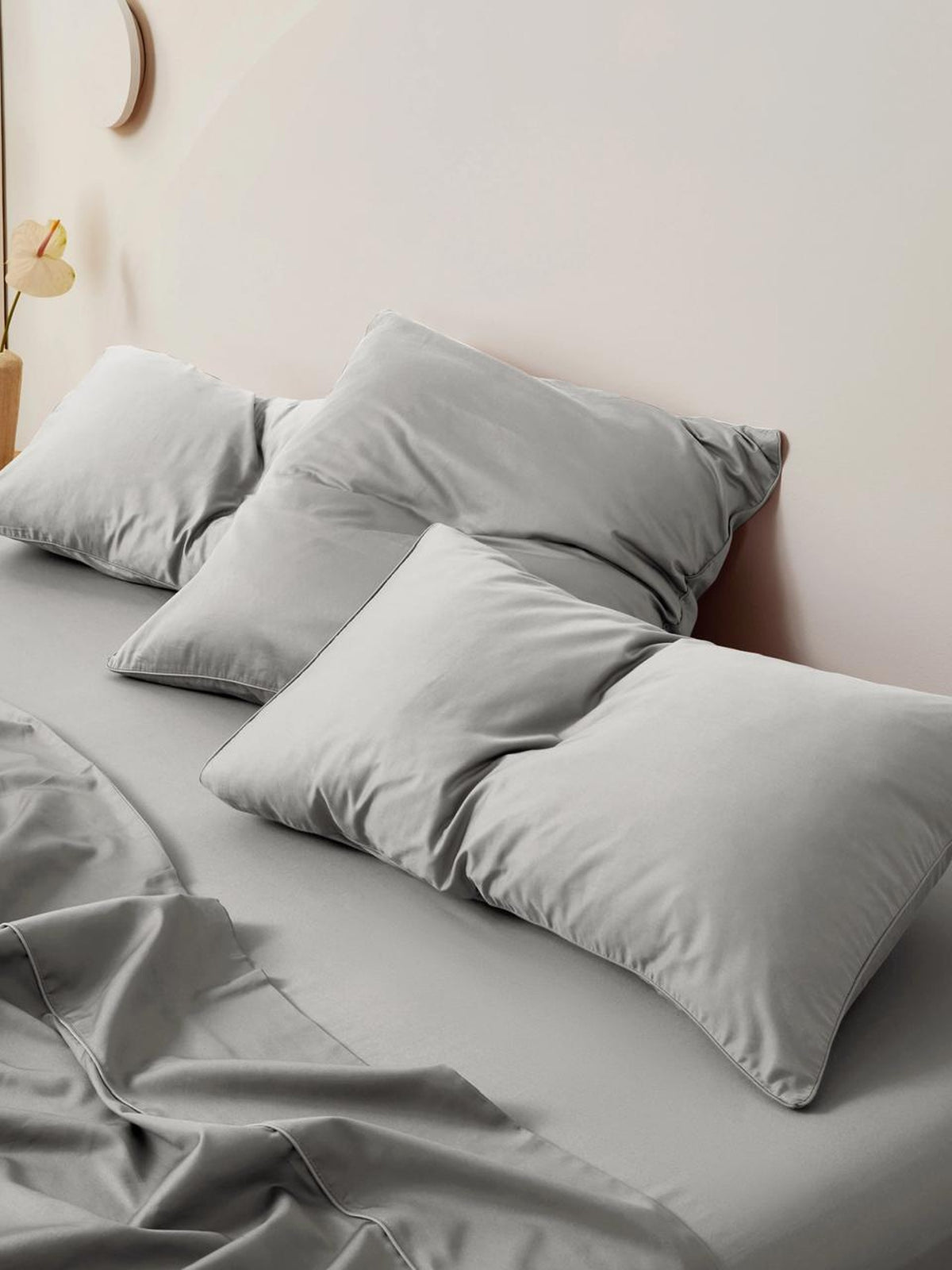 Silver grey sateen bedding and pillows on a made bed