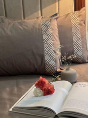 Taupe bedding with white geometric diamond embroidered pillow borders