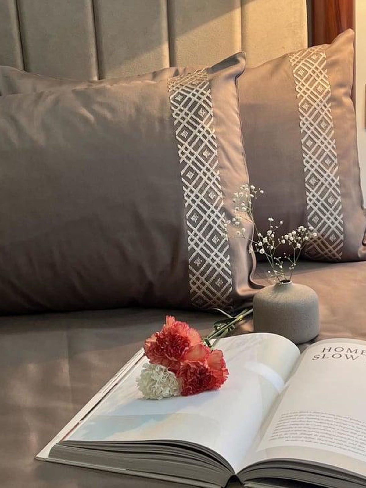 Taupe bedding with white geometric diamond embroidered pillow borders