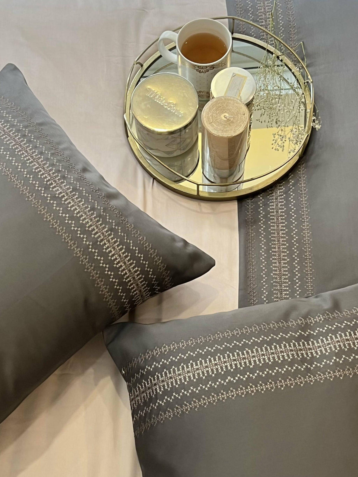 Elephant grey bedding with a cream and gold embroidered pillow band
