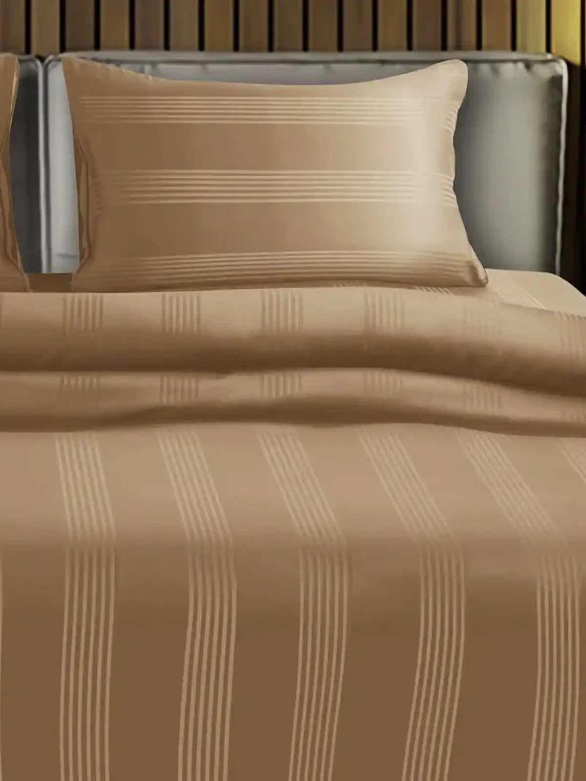 Camel tan satin stripe cotton bedsheet on a made bed with matching pillow