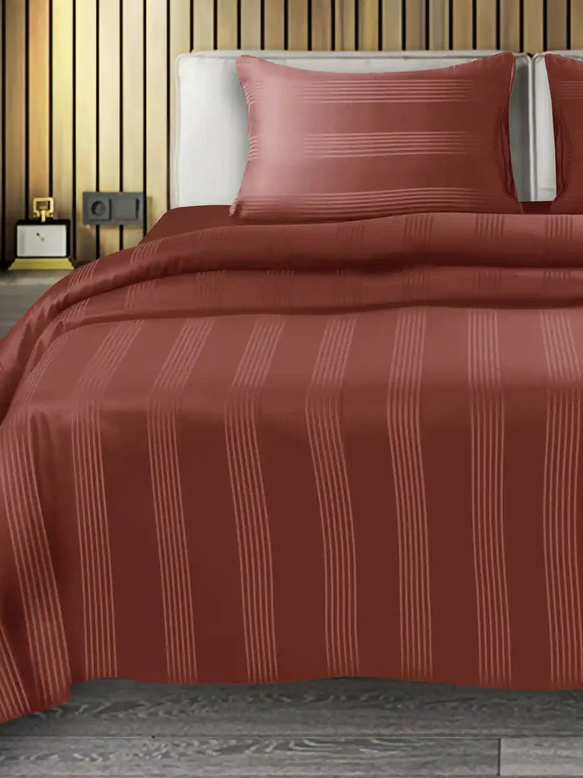 Terracotta rust satin stripe cotton bedsheet on a made bed with matching pillow