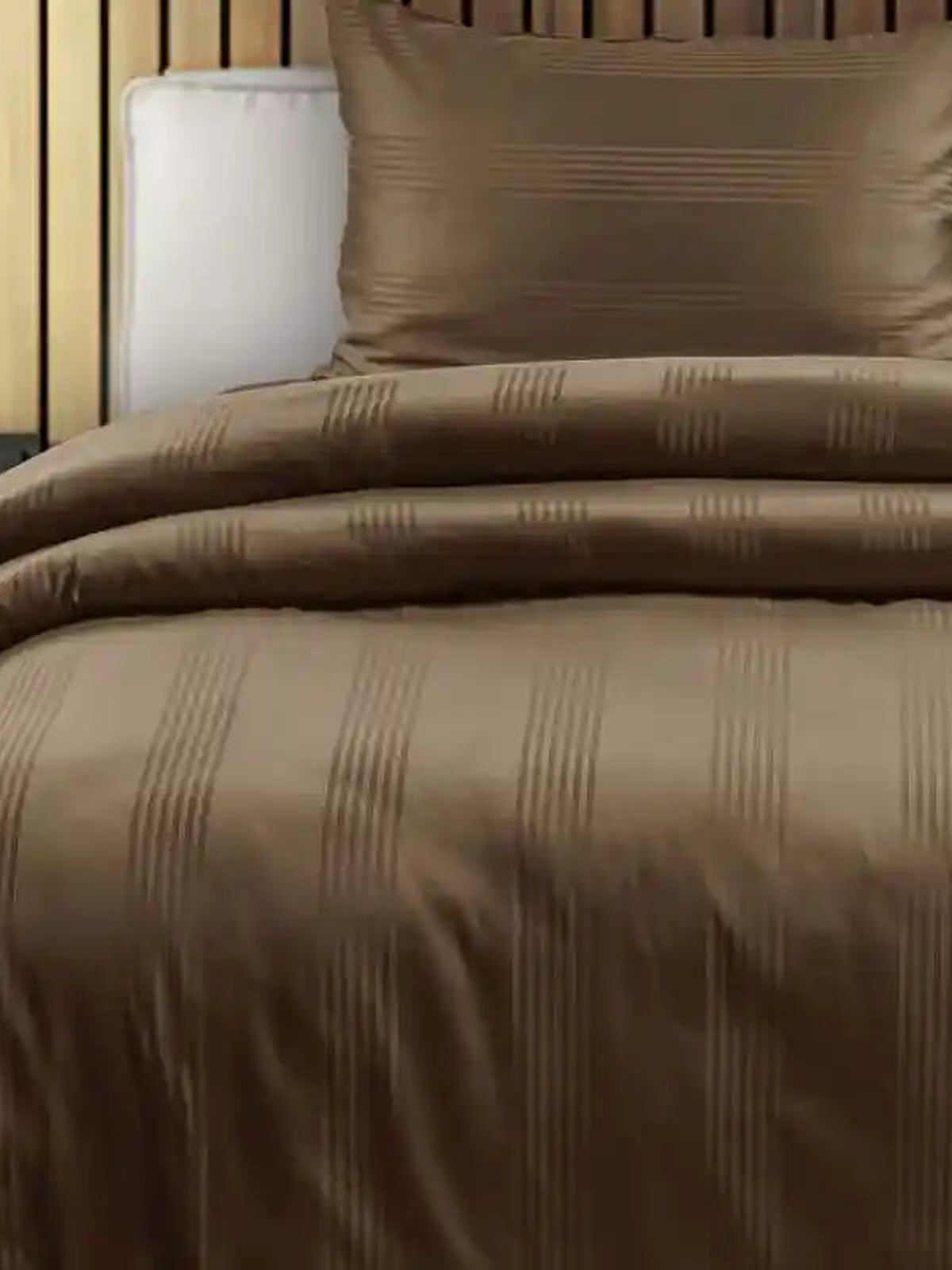 Bronze brown satin stripe cotton bedsheet on a made bed with matching pillow