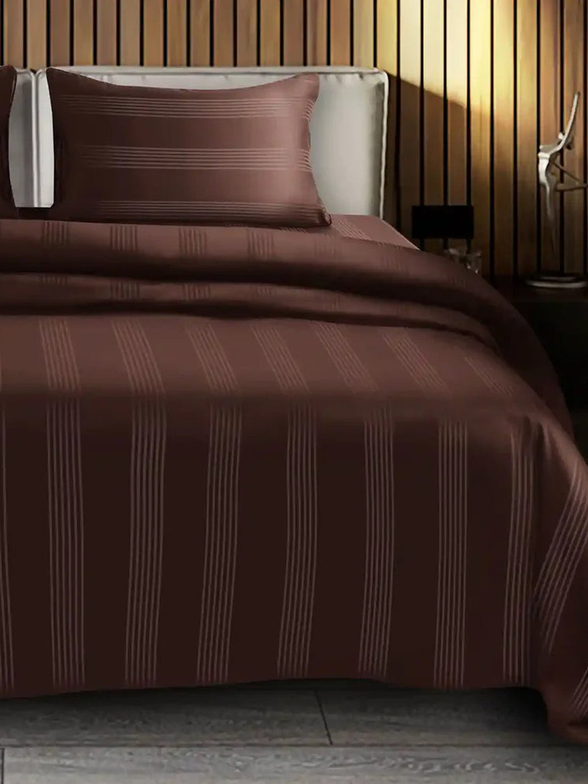 Cocoa brown satin stripe cotton bedsheet on a made bed with matching pillow