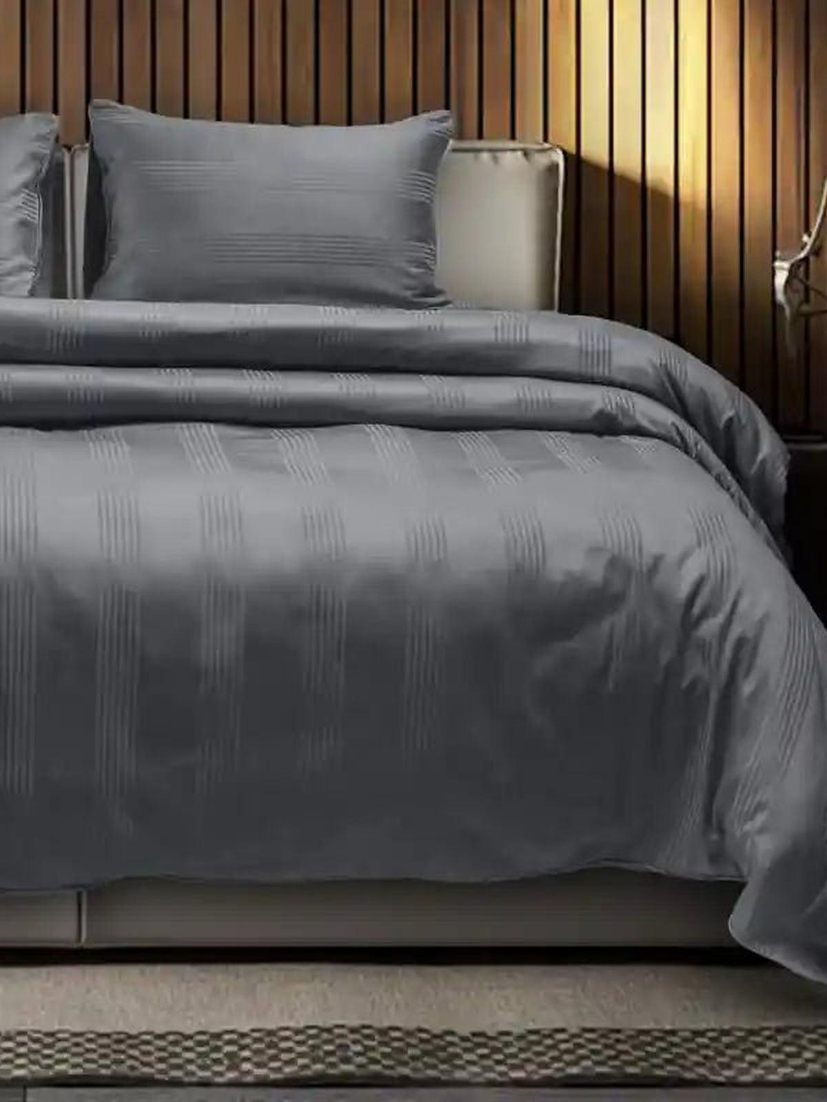 Charcoal grey satin stripe cotton bedsheet on a made bed with matching pillow