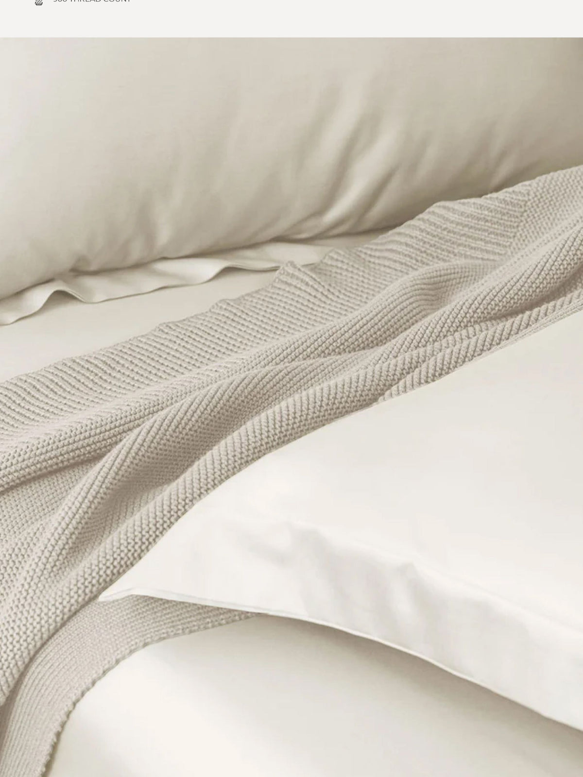 Ivory Supima cotton bedding with a waffle throw folded across it