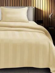 Pale butter cream satin stripe cotton bedsheet on a made bed with matching pillow