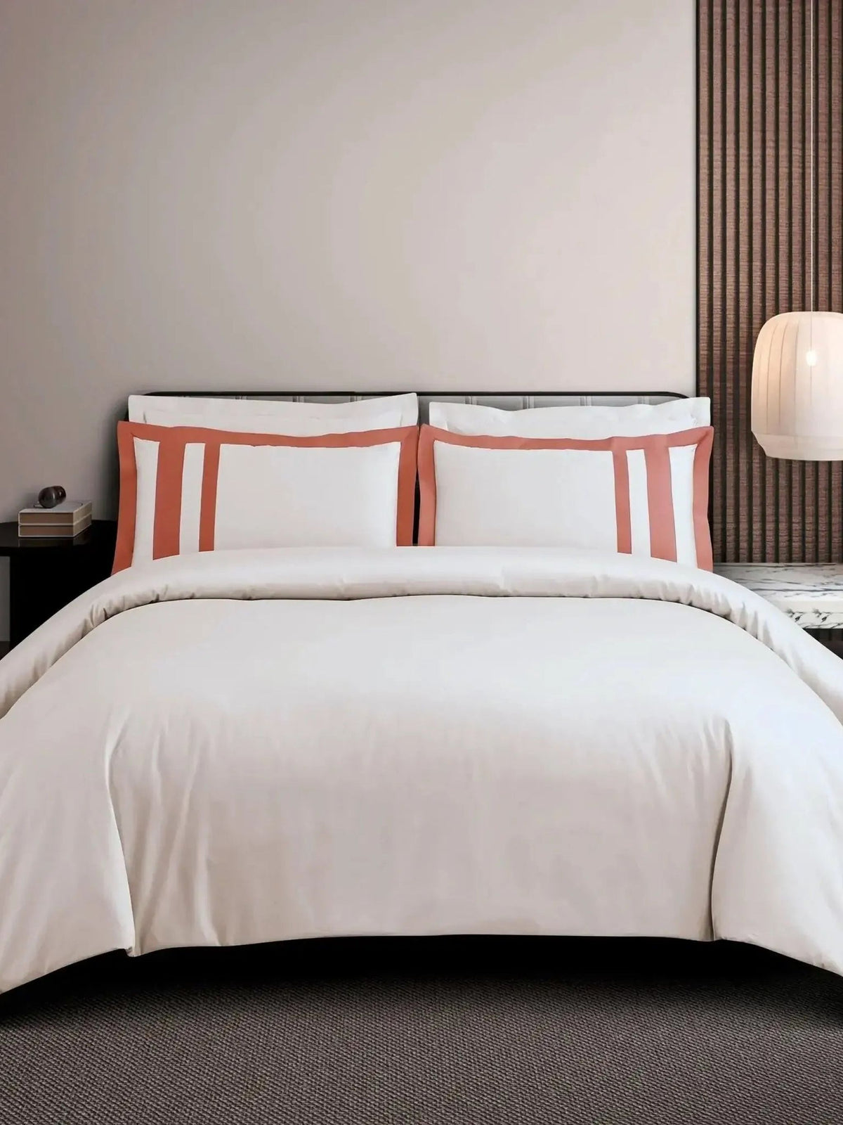 Beige cotton bedsheet set with a terracotta block-stripe border on the pillow covers, styled on a bed
