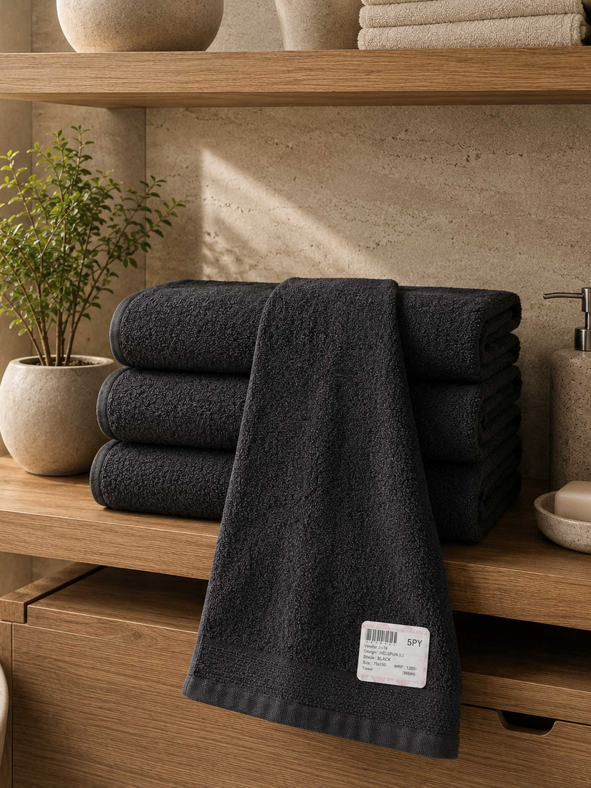 Charcoal cotton towels folded and hanging on a wooden bathroom shelf