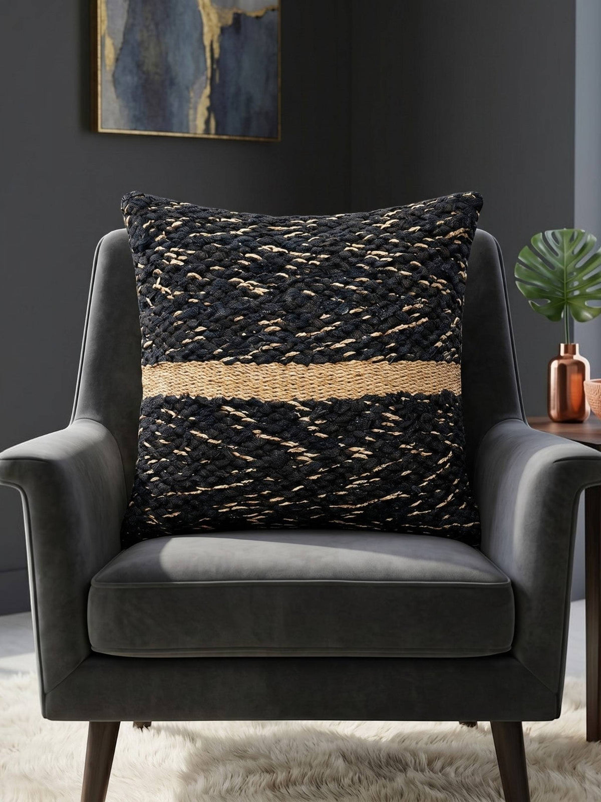 Black textured woven cushion cover with beige geometric detailing placed on a modern armchair