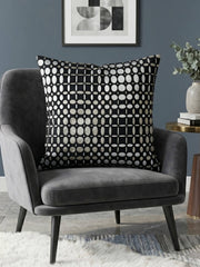 Black velvet cushion cover with geometric woven circular pattern in contrasting ivory tones