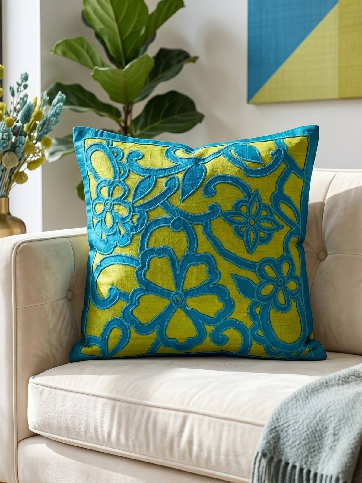 Jagdish Store decorative cushion cover with blue floral silk appliqué on a textured lime green silk-blend background.