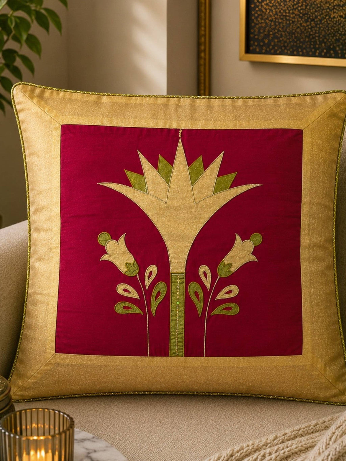 Jagdish Store decorative cushion cover with crimson red fabric, gold lotus embroidery, and gold trim. Features green accents.