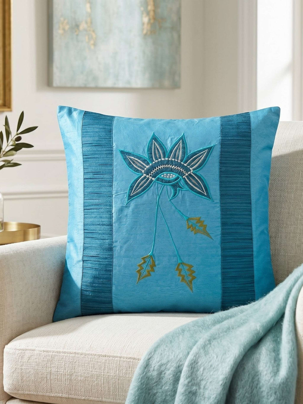 Jagdish Store embroidered decorative cushion cover in shimmering turquoise with teal, white, and gold floral embroidery and teal striped panels.